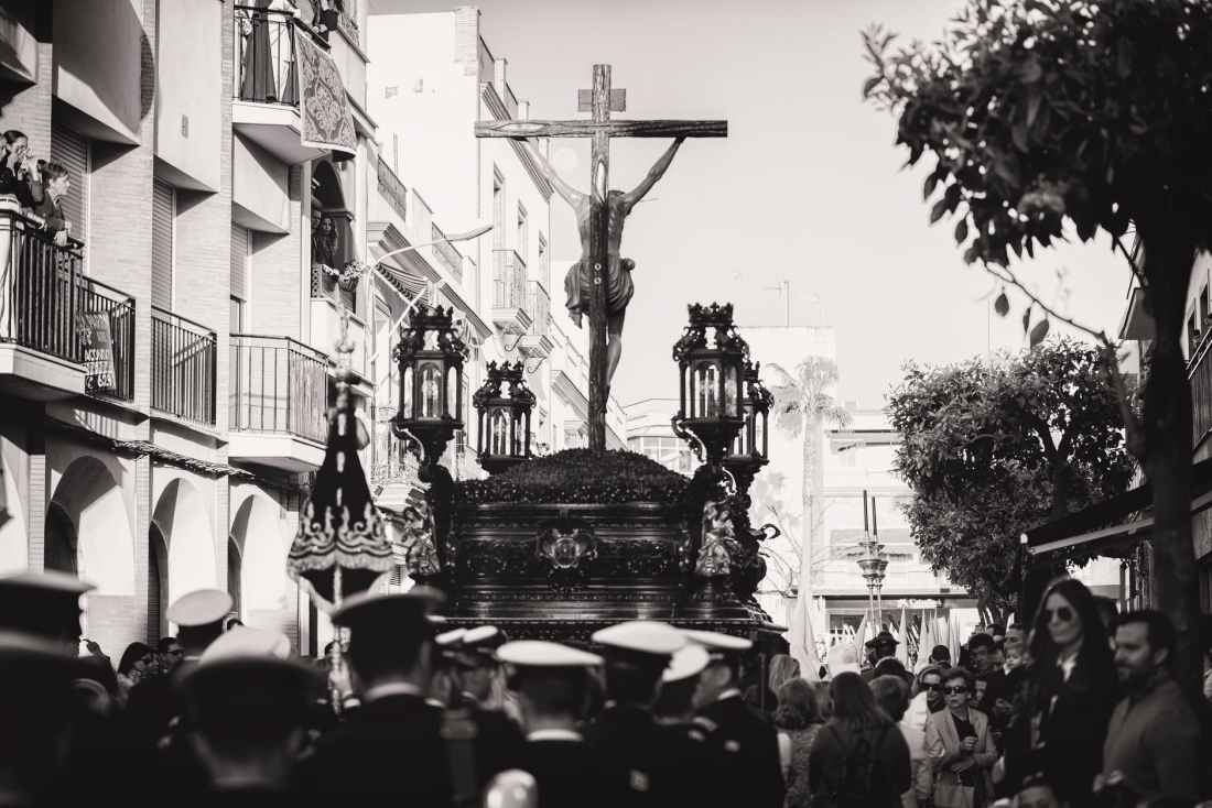 greyscale photo of group of people carrying crucifix